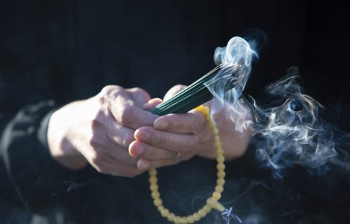 An item of the ceremony of the funeral of Japan, an incense stick.

The Japanese woman of the senior to hold an exiting incense stick of the smoke in a hand in a black mourning dress.