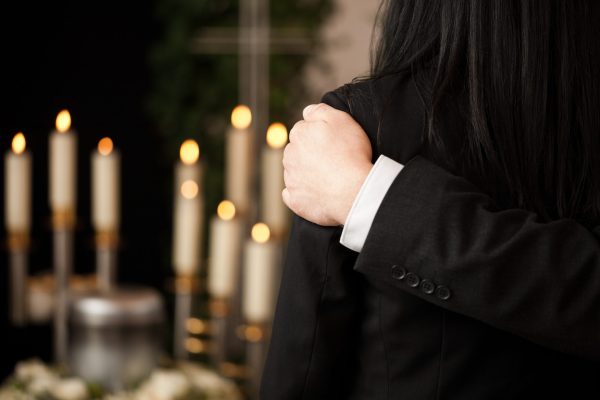 People at funeral consoling each other Religion, death and dolor - couple at funeral consoling each other in view of the loss